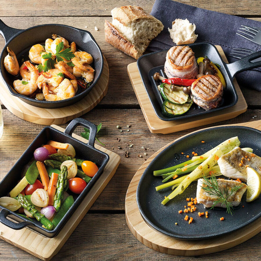 Runde Gusseisen-Grillpfanne auf Pinienholz-Untersetzer Bild 2