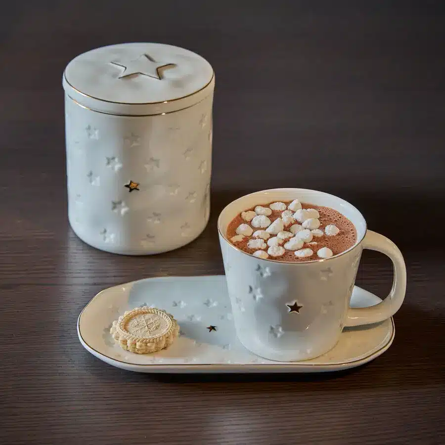 Weiße Weihnachts-Tasse mit Sternendekor und Kakao, passender Vorratsdose und Teller