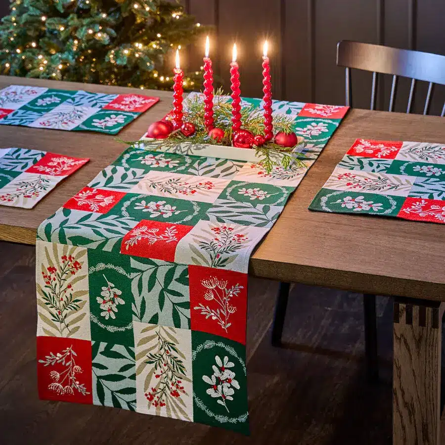 Weihnachtstisch mit bunt gemustertem Tischläufer in Rot und Grün, Kerzen als Deko