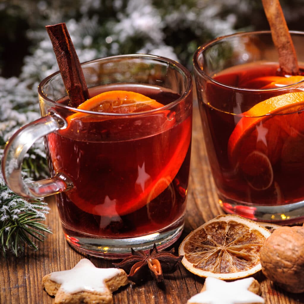 Gläser Glühwein mit Orangenscheiben, Anisstern und Zimt, weihnachtlich dekoriert