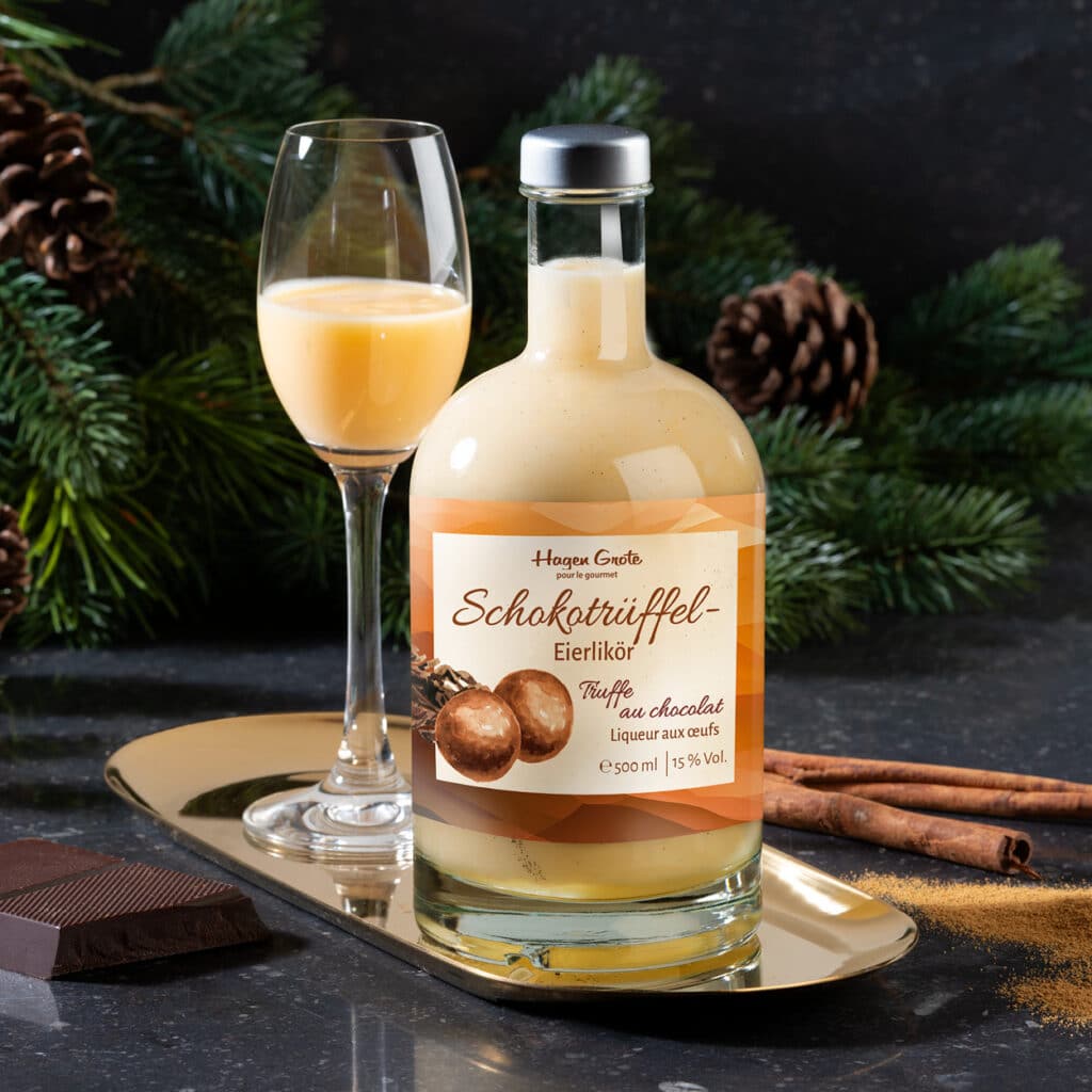 Schokotrüffel Eierlikör in Glasflasche mit Likörglas, Schokolade und Zimt weihnachtlich arrangiert