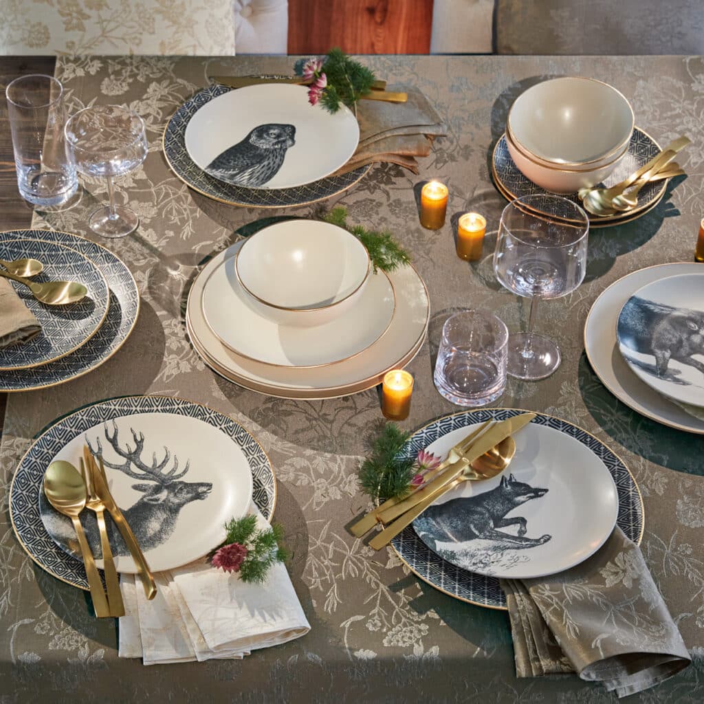 Festlich gedeckter Tisch mit Geschirr in Naturtönen, Hirsch- und Tiermotive