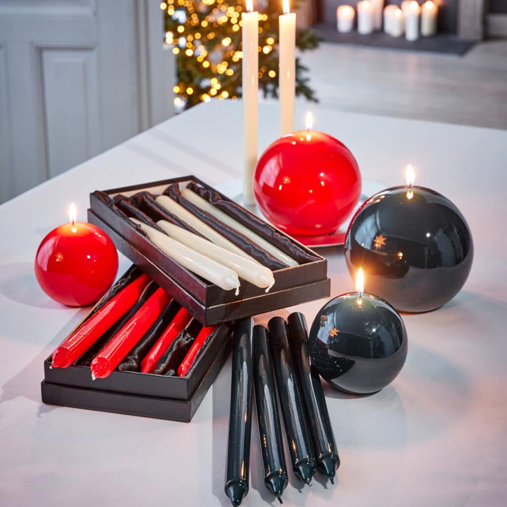 Rote, schwarze und weiße Stab- und Kugelkerzen als festliche Tischdekoration