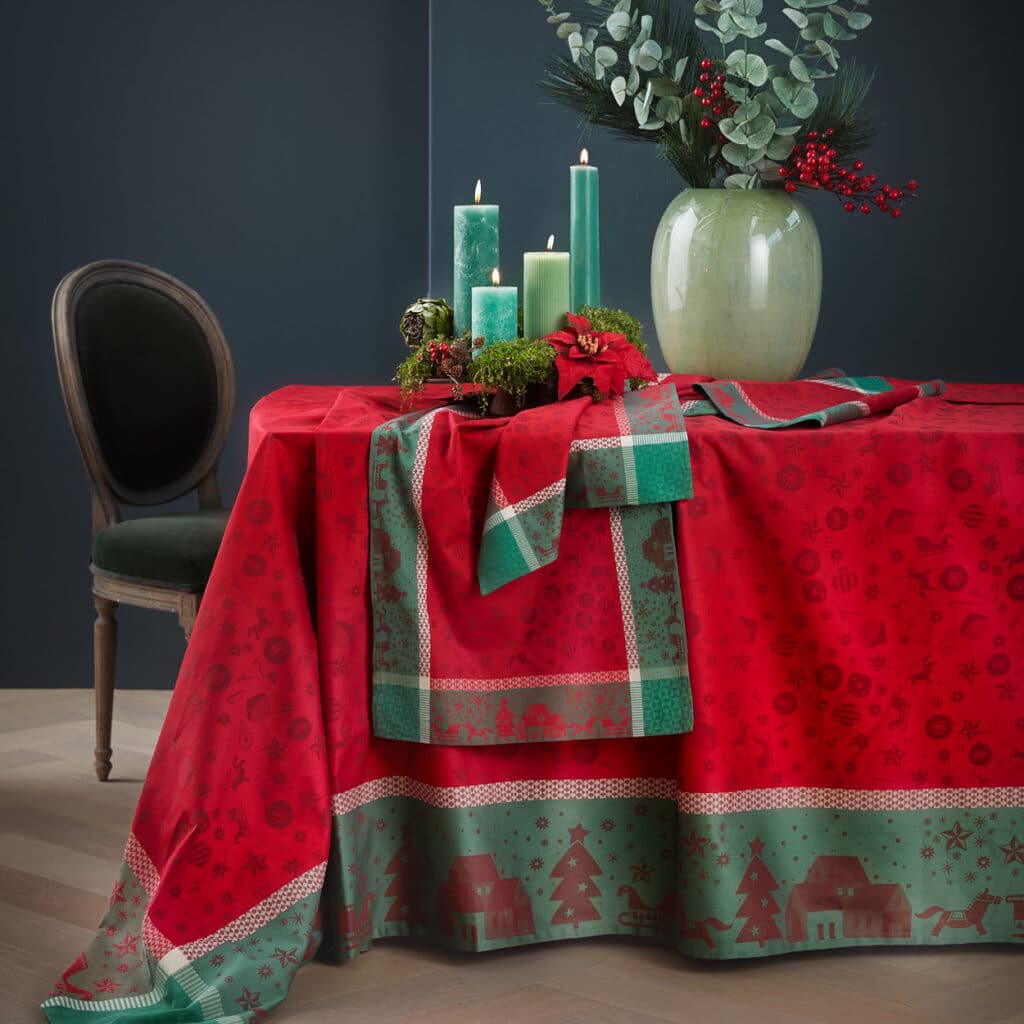 Rote Tischdecke mit grünen Bordüren und Weihnachtsmotiven, festlich arrangiert